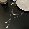 Close-up of silver-toned double-layered feather pendant necklace with zircon inlay - Double Layer Feather Tassel / Silver Necklace
