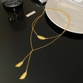 Macro view of gold double-layer necklace featuring sparkling zircon feather pendants - Double Layer Feather Tassel / Gold Necklace