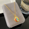 Collar de relicario dorado con colgante de conejo de esmalte azul sobre joyero gris - Estilo Conejo Azul Flor (W986)