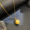 Elegante collar dorado con colgante de caja de circón sobre fondo mineral negro texturizado - Águila de Circonita Blanca Ovalada