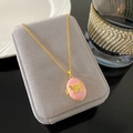 Collar de relicario ovalado de esmalte rosa con mariposa dorada sobre joyero gris - Estilo Mariposa Esmalte Rosa (W1002)