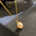 Golden sunburst necklace with oval pearl pendant and starry details on grey stone base - Oval Pendant Pearl Star (W1032)