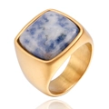 Gros plan d'une bague en acier titane brossé doré avec pierre naturelle bleue carrée - Or Sodalite Bleue