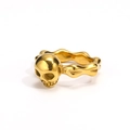 Detailed macro view of the gold skull relief and wave texture on the titanium steel ring - US 5 / Gold