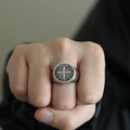 Detail eines Vintage-Siegelrings mit Benediktuskreuz aus mattem Silberstahl am Finger - Zweifarbig Schwarz