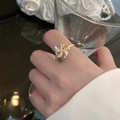 Macro detail of rotating gold windmill ring with white zircon stones and adjustable band - Pinwheel Ring / Gold