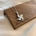 Rotating silver windmill necklace with sparkling crystals on a wooden display stand - Pinwheel Necklace / Silver