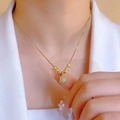 Golden necklace with sunflower pendant and textured beads worn on a model with a white suit - Gold Durian Style (6 Blessing Beads)