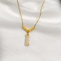 Macro shot of gold floral necklace with white jade pendant and red crystal detail - Gold Bamboo Style (6 Blessing Beads)