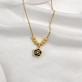 Detail view of gold necklace featuring black floral pendant and frosted beads on a box chain - Gold Camellia Style (6 Blessing Beads)