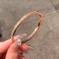 Rose gold titanium steel bracelet with full pave zircon stones in a hand-held view - Starry Sky Bangle / Rose Gold