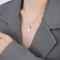 Zilveren gelukszakje ketting met witte chalcedoon hanger op een vrouwelijk model - O ketting / Zilver