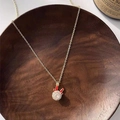 Detail of gold necklace featuring a bunny ear pendant with a sparkling crystal center - Red Rotating Reindeer Necklace