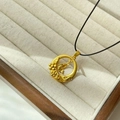 Golden fish pendant necklace on black cord in elegant beige jewelry box display - Gold - Fish Ring Black Cord