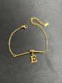 Detailansicht eines goldenen Kettenarmbands mit fettem E-Anhänger und Karabinerverschluss - Buchstabe E