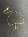 Detail eines verstellbaren goldfarbenen Armbands mit N-Anhänger, Karabiner und Verlängerung - Buchstabe N