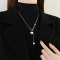 Elegante collana d'argento con pendenti a cuore e stella su un blazer nero chic - Collana Nappina Cuore Stella Argento