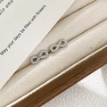Detailed view of sterling silver infinity stud earrings with sparkling zircon stones - Stud Earrings / Silver
