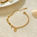 Pulsera de doble capa en acero de titanio con colgante de trébol dorado sobre arena - Cadena de Caja Cuadrada de Doble Capa Oro