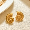 Macro shot of conch-shaped vintage earrings with detailed texture on beach background - Conch Style / Gold Conch Stud Earrings