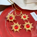 Macro detail of vintage gold starburst jewelry set with red stones in a red velvet tray - Red Sunflower Vintage Set (A528)