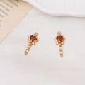 Macro detail of heart-shaped magic wand charms with red ruby stones and gold wings - Dark Red