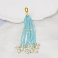 Detalle de borla de cuentas azul claro con perlas blancas de imitación y anillo dorado - Aguamarina