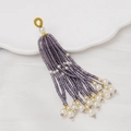 Vista macro de borla de cuentas moradas con perlas y detalles dorados para joyas DIY - Púrpura Oscuro