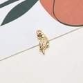 Macro shot of gold-plated parrot pendant with white cubic zirconia and red gem eye - Parrot Design