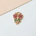 Detail eines goldenen Schmetterlingsanhängers mit Zirkonia-Steinen und Doppelringen - Rosérot