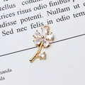 Macro shot of gold floral pendant featuring marquise-cut zircon petals on vintage paper - White