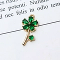 Macro shot of gold floral jewelry pendant with emerald green teardrop zircons on paper - 03# Green