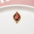 Detalle macro del conector de cristal granate con bisel festoneado dorado para joyería DIY - Rosa Loto