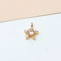 Macro detail of gold-plated snowflake pendant featuring zircon center and prong setting - Star White