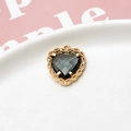 Close-up of gold-plated heart pendant with grey gemstone and intricate lace metal edges - Dark Gray
