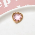 Macro-opname van een roze hartvormige hanger met gouden kanten rand op keramisch bord - Roze