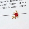 Detail of golden reindeer pendant featuring a red pear-shaped zircon gemstone inlay - Red Reindeer