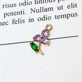 Macro shot of gold floral pendant with purple zircons and green marquise stone - Flower Purple