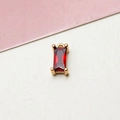 Macro detail of a rectangular red zircon pendant with gold plated brass claws for DIY jewelry - Burgundy