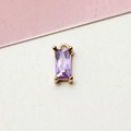 Macro shot of a rectangular purple zircon pendant with a gold-plated copper base - Violet