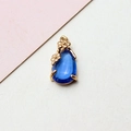 Macro detail of royal blue teardrop pendant with golden flower prongs for jewelry making - 8*17MM / Light Blue