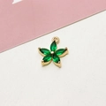 Macro detail of a 5-petal gold plated flower pendant with marquise green zircon stones - Green