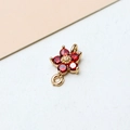 Macro view of a gold-plated flower charm with red zircon stones and dual loop connectors - Red