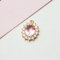 Macro shot of pink oval crystal pendant with zircon sunflower halo and golden clasp - 14*19mm / Pink