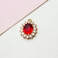 Close-up of an oval red gemstone pendant with white zircon cluster setting in gold - 14*19mm / Red