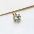Macro shot of light blue zircon stone enclosed in a gold-plated cage pendant charm - Small / Light Blue