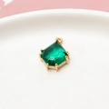 Close-up of an emerald green shield-shaped gemstone pendant with a gold metal frame - Peacock Green