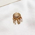 Macro detail of a gold hollowed Fu character pendant with zircon tassels on white silk - No.01 / White