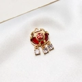 Macro detail of a golden Fu lock pendant with a red gemstone and zircon accents - No.02 / Red