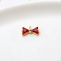 Macro detail of a golden bow pendant with red triangular zircons for DIY jewelry making - Red Single Hanging Bowknot (LF2239)